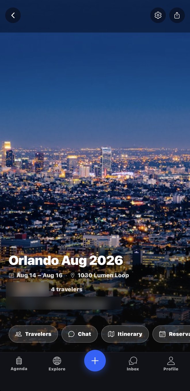 A trip's hub: a full-width cover photo of the city at night, the dates, the travellers, and buttons for chat, itinerary and reservations.